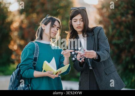 Étudiant et enseignant examinant un modèle moléculaire à l'extérieur lors d'une session d'étude scientifique Banque D'Images
