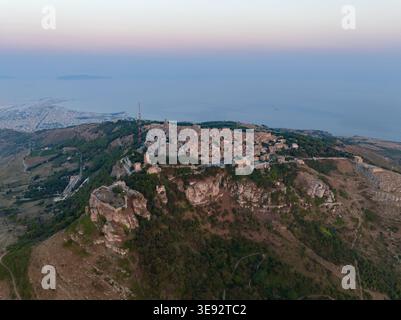 Vue aérienne de la ville historique perchée sur une colline d'Erice perchée sur une falaise rocheuse avec des bâtiments en pierre et la côte méditerranéenne en arrière-plan Erice, S. Banque D'Images