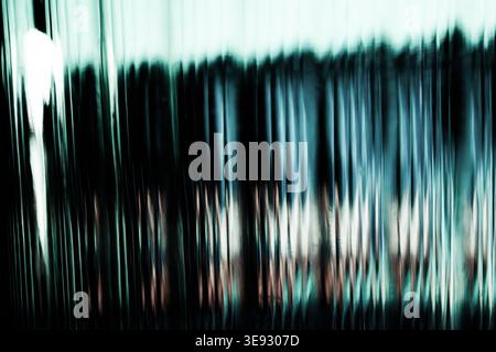 Reflets de lumière floue verticaux dans des tons bleu sarcelle et blanc pour créer un effet de pépins cinématographiques Banque D'Images