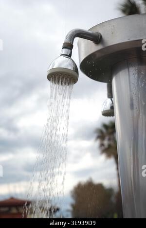 L'eau coule d'une pomme de douche dans un cadre extérieur Banque D'Images