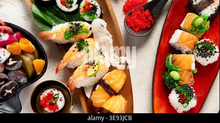 Assiettes de Sushi assorties avec des desserts sur un fond clair. Vue de dessus. Banque D'Images