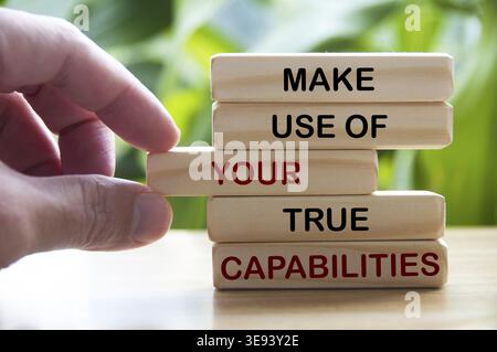 Utilisez vos véritables capacités texte sur des blocs de bois avec main et flou de fond de nature. Concept de motivation Banque D'Images