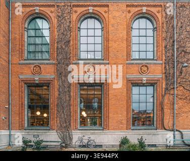 Façade historique du bâtiment en briques rouges avec fenêtres cintrées et Ivy grimpant, look académique Banque D'Images