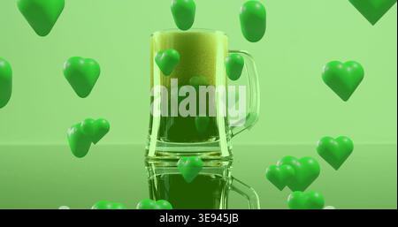 Montrant la tasse de bière en verre avec poignée tenant la boisson verte mousseuse sur l'avion brillant, jetant des coeurs verts Banque D'Images