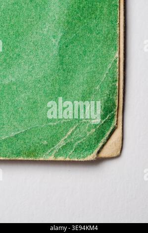 Une photo macro détaillée révèle la texture vieillie et les dommages sur une surface de papier vert, mettant en évidence son histoire et ses imperfections Banque D'Images