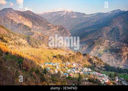 Une vue aérienne à couper le souffle d'un village de montagne niché au cœur du temple Tungnath, Uttarakhand, Inde, entouré de verdure luxuriante et majestueuse Banque D'Images