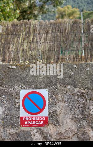 Majorque. Espagne - 17 avril 2026 : un plan vertical montre un panneau espagnol Prohibido Aparcar no parking signé Normaluz monté sur un mur rustique en pierre surmonté Banque D'Images