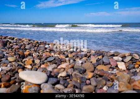 Côte de pierre de la mer du Nord faite de petits pavés. Pierres sur la plage. Galets sur le littoral. Banque D'Images
