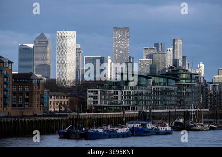 Appartements résidentiels et immeubles d'appartements au bord de la rivière le long de la Tamise à Wapping regardant vers les gratte-ciel du quartier financier de Canary Wharf le 28 février 2026 à Londres, Royaume-Uni. Canary Wharf est une zone située près de l'île des chiens dans le quartier londonien de Tower Hamlets et est définie par la Greater London Authority comme faisant partie du quartier central des affaires de Londres. Avec la City de Londres, elle constitue l'un des principaux centres financiers du Royaume-Uni et du monde, avec de nombreux immeubles de grande hauteur, dont le troisième plus haut du Royaume-Uni, One Canada Squ Banque D'Images