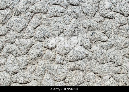Gros plan de texture de surface de mur en pierre de granit rugueux avec motif naturel. Banque D'Images
