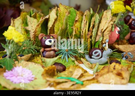 bébé artisanat d'automne à la maternelle, escargot en plastique sur feuilles jaunes Banque D'Images