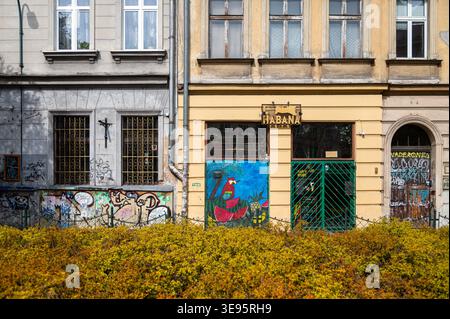 Cracovie, Pologne - 12 avril 2026 : vue sur les bâtiments Kazimierz, graffiti sur les murs et verdure devant. Banque D'Images