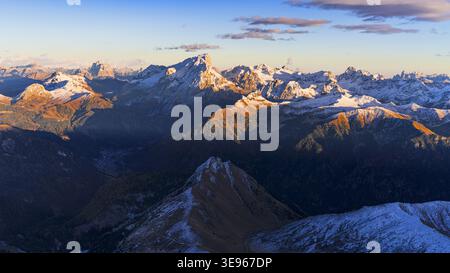 Vue aérienne des sommets enneigés ensoleillés et des vallées ombragées créent une tapisserie spectaculaire de lumière et d'obscurité à travers le paysage montagneux, Dolomites, Banque D'Images