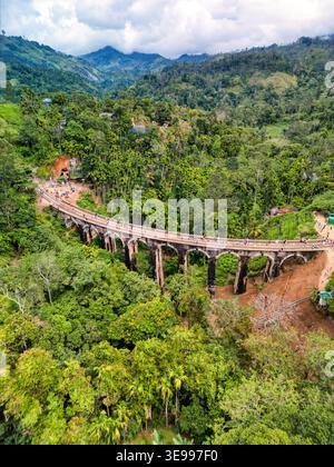 Vue aérienne du pont historique des neuf Arches avec des gens marchant le long des pistes entourées par une forêt tropicale luxuriante et des montagnes brumeuses à Demodara, Banque D'Images