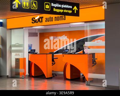 Riga, Lettonie - 03 avril 2026 : comptoir de location de voitures Sixt dans un aéroport avec la marque orange et la signalisation, mettant en valeur un design moderne et un service à la clientèle Banque D'Images