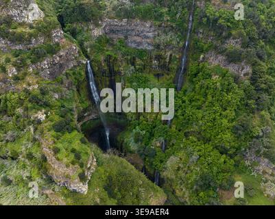 Vue aérienne de plusieurs cascades descendant des falaises verdoyantes et un terrain rocheux Madère, Portugal. Banque D'Images
