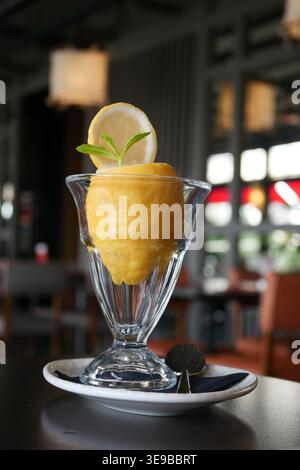 Sorbet au citron jaune dans une tasse en verre transparent sur la table Banque D'Images