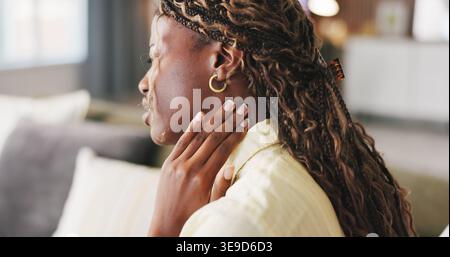 Stress, tension et femme avec douleur au cou sur canapé pour crampes musculaires, raideur et nerf pincé. Inconfort, personne noire et fatigue articulaire à la maison avec Banque D'Images