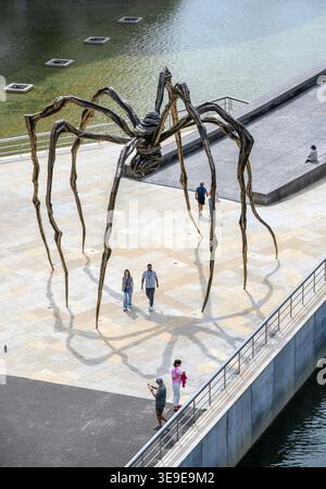 Les visiteurs passent devant la sculpture d'araignée géante « Maman » de l'artiste française Louise Bourgeois au bord de la rivière au musée Guggenheim, Bilbao, Biscaye, Ba Banque D'Images