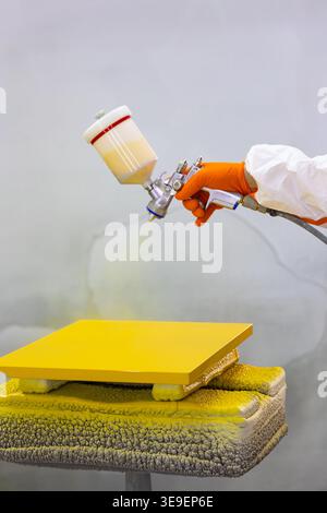 Peinture au pistolet de pulvérisation panneau jaune Fermer le processus de revêtement industriel Banque D'Images