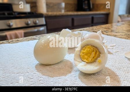 Oeufs durs sur le comptoir de cuisine avec coquille pelée et oeuf partiellement mangé montrant le jaune Banque D'Images