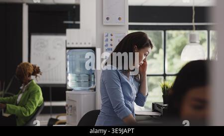 Directeur d'entreprise traitant avec mal de tête douloureux dans le bureau essayant de travailler sur un nouveau projet d'investissement. Jeune femme frottant les tempes ayant la migraine dans le bureau de démarrage d'entreprise. Prise de vue à main levée. Banque D'Images