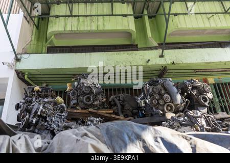 Pile de vieux moteur et de pièce de voiture automatique dans la cour sombre de ferraille de junkyard en attente de réparation de machine mécanique. Composant de véhicule métallique oublié abando Banque D'Images