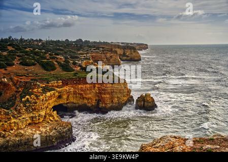 La côte portugaise de l'algarve présente des falaises de grès escarpées, des grottes marines et un littoral rocheux, avec de puissantes vagues de l'océan atlantique qui s'écrasent Banque D'Images