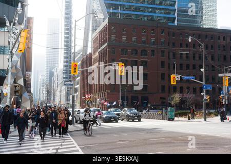 Toronto, Canada - 17 avril 2026 : intersection animée avec divers voyageurs. Scène urbaine vibrante avec des piétons Banque D'Images