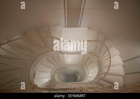 Escalier en colimaçon vu d'en haut en Sicile, Italie. Perspective architecturale montrant des motifs ovales concentriques avec des rampes métalliques et des murs blancs cr Banque D'Images