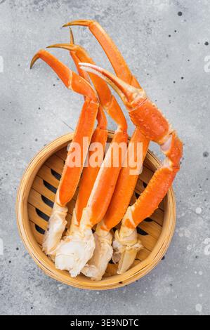 Fruits de mer de crabe roi d'alaska de qualité supérieure cuits et nettoyés dans un panier vapeur en bois style restaurant à fond lumineux. Banque D'Images