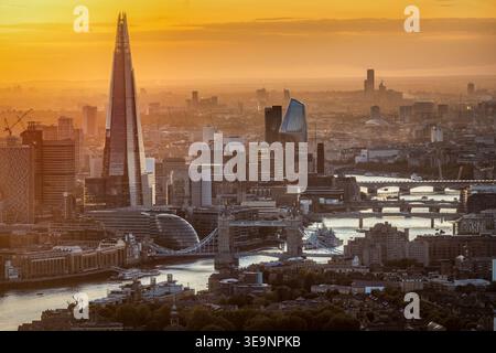 Coucher de soleil d'automne doré derrière l'horizon urbain de Londres, en Angleterre, avec les différents ponts sur la Tamise Banque D'Images