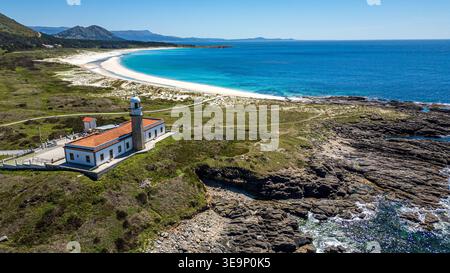 Une vue aérienne spectaculaire capture le phare de Punta Insua à Lariño. La structure historique surplombe un littoral accidenté qui s'ouvre sur un vaste wh Banque D'Images
