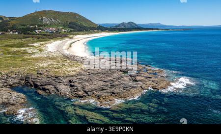 Un panorama aérien spectaculaire capture la côte galicienne accidentée à Lariño. Les eaux cristallines de l'Atlantique se baignent contre la plage de sable blanc et roc Banque D'Images