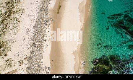 Une vue aérienne spectaculaire de haut en bas capture les couleurs vives de la plage de Lariño en Galice. Le sable blanc fin alterne avec une bande naturelle de p gris Banque D'Images