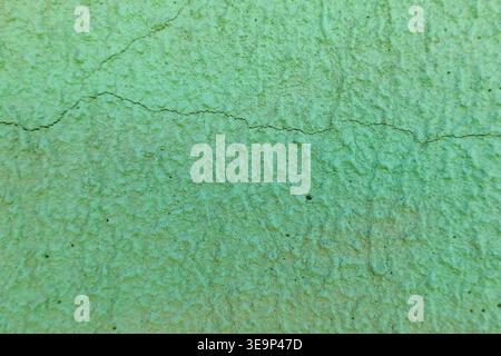 Mur vert avec surface texturée rugueuse et fissures sur fond Banque D'Images