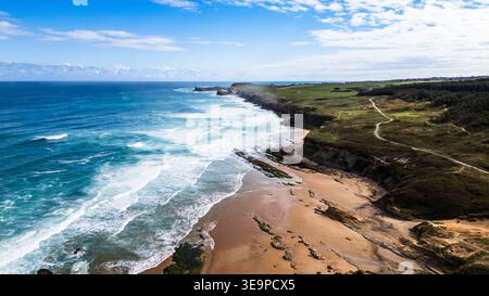 Vue aérienne spectaculaire de la Costa Quebrada en Cantabrie, Espagne. Les vagues mousseuses de la mer Cantabrique s'écrasent sur la plage de Canallave, tandis qu'un sentier côtier Banque D'Images
