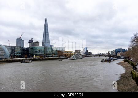 Un paysage urbain dynamique mettant en vedette l'emblématique Shard surplombant la Tamise à Londres, au Royaume-Uni. L'architecture moderne des bâtiments voisins contraste Banque D'Images