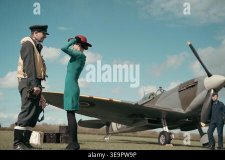Le pilote de la RAF discute avec une femme en robe verte à côté du Spitfire MkVc EE602 à l'aérodrome de Sywell, Battle of Britain reconstitument. Banque D'Images