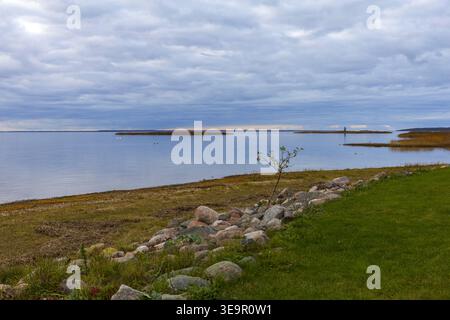 Scène côtière avec des pierres et de l'eau calme sous ciel couvert en Estonie. Banque D'Images