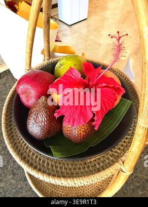 Panier de fruits tropicaux avec des fruits de serpent et une jolie fleur d'hibiscus Banque D'Images