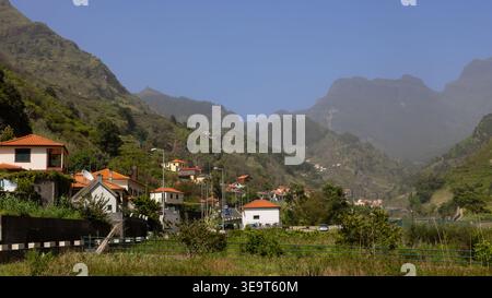 Maisons parsemées d'un paysage de montagne verdoyant dans la vallée de Sao Vicente, Madère Banque D'Images