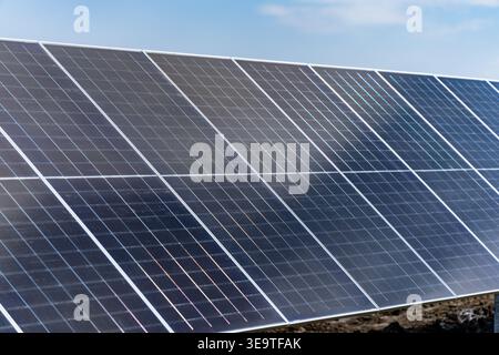Grande rangée de panneaux solaires photovoltaïques modernes installés dans le champ extérieur pour la production d'énergie renouvelable et le développement durable du réseau électrique pour gr Banque D'Images