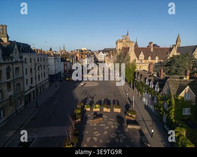 Vue aérienne par drone le long de Broad Street dans le centre-ville d'Oxford à l'aube, avec les bâtiments universitaires historiques dans la lumière chaude du matin Banque D'Images