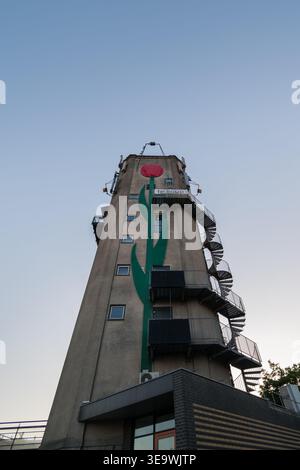 Château d'eau avec murale de tulipe rouge et tige verte avec escalier d'évacuation en spirale en métal à Roelofarendsveen, pays-Bas. Banque D'Images