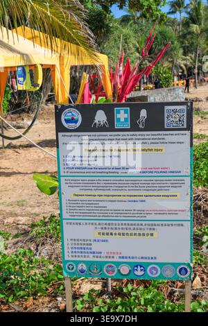 Ce cliché vertical à hauteur des yeux comporte un panneau de sécurité publique détaillé à Karon Beach, Phuket, fournissant des instructions de premiers soins pour les piqûres de méduses. Th Banque D'Images