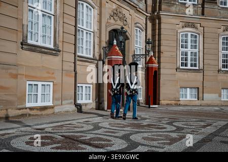 Copenhague, Danemark - 25 mars 2026 : les gardes de sauvetage royaux danois en uniformes bleus traditionnels et chapeaux en peau d'ours sont en service au palais d'Amalienborg Banque D'Images