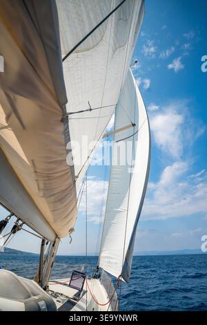 Côté d'un yacht à voile coupant à travers la mer avec des voiles pleines près de la Croatie. Mouvement, liberté, style de vie nautique et aventure sur l'eau libre. Banque D'Images