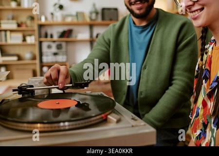 Amis adultes jouant au disque vinyle pour la campagne Home Entertainment Banque D'Images