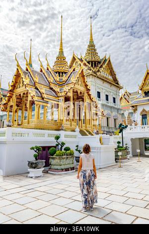 Charmante femme regardant le stupa doré et les pagodes, Grand Palais, Bangkok, Thaïlande Banque D'Images